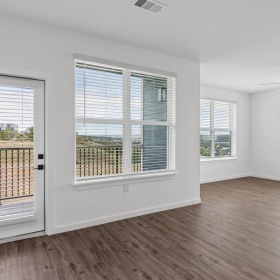 a living room with wood floors and windows